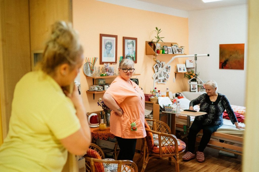 Freundliche Pflegekraft kümmert sich um eine Seniorin zu Hause