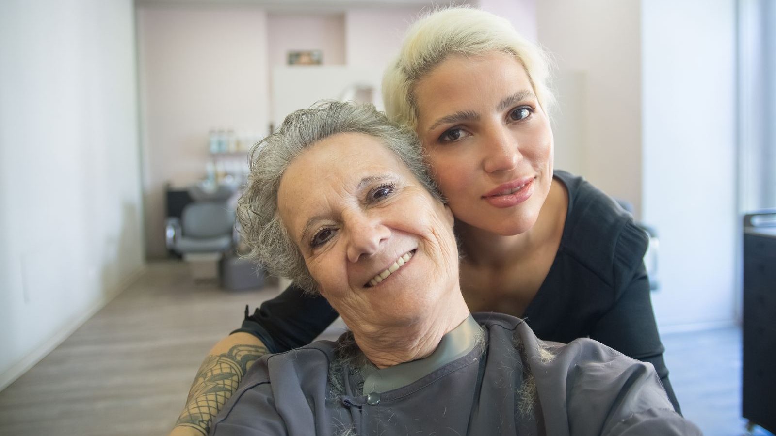 Pflegerin im Gespraech mit aelterem Mann am Tisch